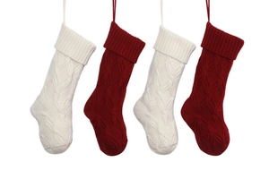 Close-up of four knitted Christmas stockings in red and white with hanging loops