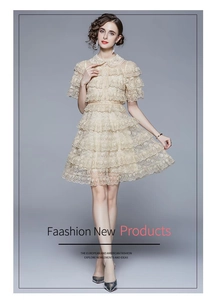 Detail of champagne lace dress showing ruffled tiers and pearl buttons on the front