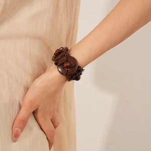Close-up of ethnic geometric coconut shell and wood bead elastic bracelet worn on wrist