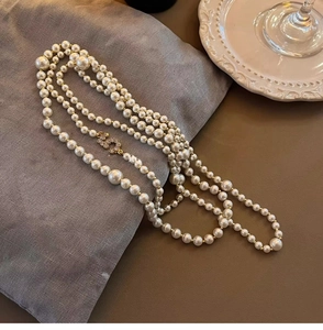 Close-up of elegant multi-layer pearl necklace with sparkling gold zircon buckle detail