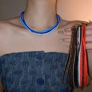 Detail of multi-layer beaded necklace featuring colorful seed beads and gold metal closures