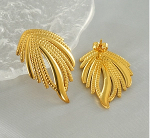 Detailed macro shot of vintage woven feather style gold plated stainless steel earrings