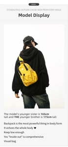 Back view of a yellow lightweight nylon drawstring backpack worn by a model