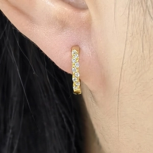 Close-up of S925 sterling silver geometric hoop earring with pavé set white stones on ear