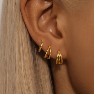 Close-up of three layered gold S925 sterling silver hoop earrings on model ear
