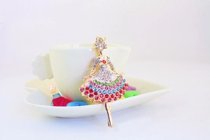Macro shot of dancing angel keychain with colorful rhinestones on a white tea cup base