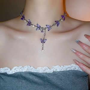 Close-up of purple butterfly crystal pendant necklace with shiny silver chain on neck