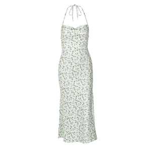 Detail of white halter neck dress featuring green floral patterns and flowing fabric texture