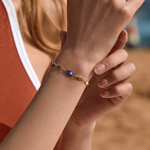 18K gold-plated brass chain bracelet with blue evil eye palm charms on model wrist