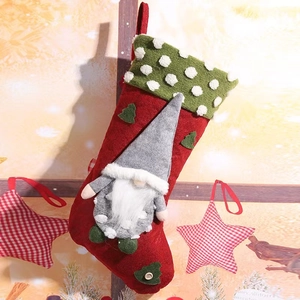 Calza di Natale rossa con risvolto a pois verdi e decorazione di gnomo grigio