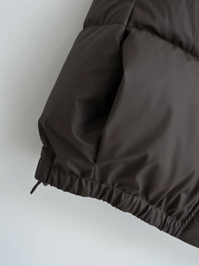 Detail of adjustable drawstring hem on street style stand collar puffer vest
