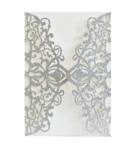 Macro detail of silver glitter laser cut lace pattern on wedding invitation cover