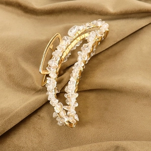 Detail of handmade gold metal hair claw clip with natural transparent crystal stones