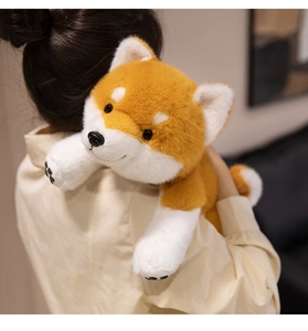 Close-up of soft plush Shiba Inu doll showing detailed black paw embroidery and fur texture
