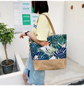 Detailed view of the large canvas tote bag with tropical floral print on a female model