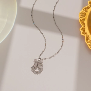 Detailed view of silver butterfly and circle pendant necklace with micro-pave zircons