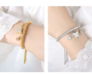 Close-up of gold and silver beaded bracelets with sparkling butterfly charms on wrist
