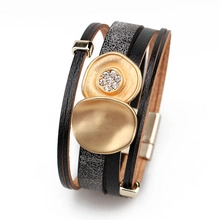 Detail of multi-layer leather bracelet with gold charms, crystals and magnetic clasp
