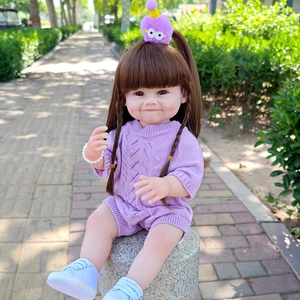 Detailed outdoor shot of a 55cm lifelike baby doll in purple knitwear and blue sneakers