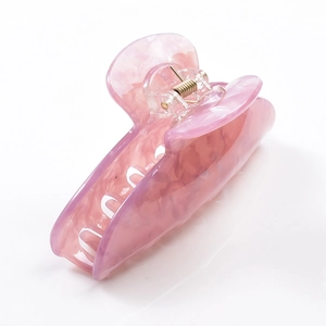 Detail shot of a large pink marble acrylic shark hair claw clip with metal spring