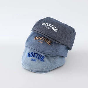 Close-up of Boston 1630 embroidery detail on washed denim berets for babies