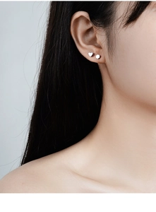 S925 sterling silver geometric stud earrings shown in a layered multi-piercing style
