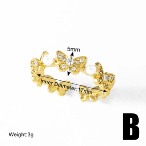 Detailed view of 17mm gold butterfly ring with small pearls and clear gemstones