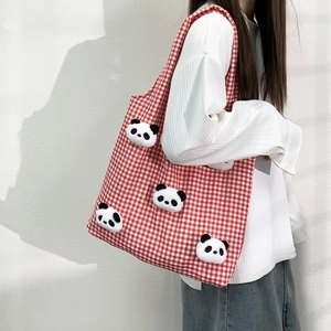 Detail of red gingham canvas tote bag featuring five plush 3D panda dolls on the side