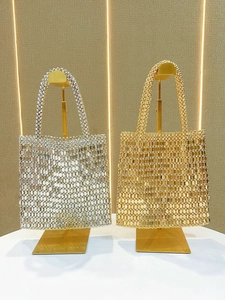 Chic silver and gold metallic sequin tote bags displayed on luxury T-shaped stands