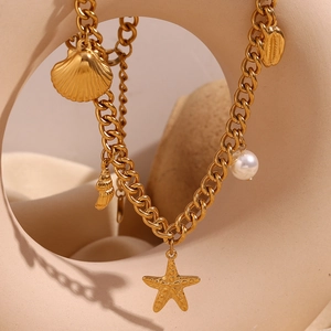 Close-up of 18K gold plated ocean-themed necklace with shell, starfish and pearl charms