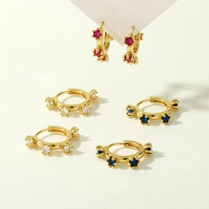 Close-up of gold-plated zircon hoop earrings in red, white, and deep blue flower motifs