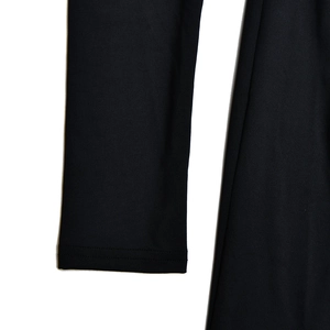 Détail de la texture en maille noire et coutures soignées des manches de la robe
