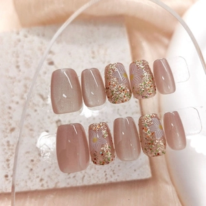 Detailed view of press-on nails featuring cat eye effect and white daisy floral patterns