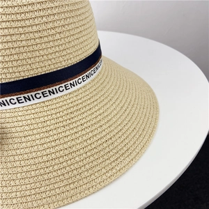 Gros plan détaillé de la texture en paille tressée et du ruban décoratif sur le chapeau