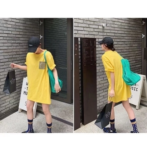 Oversized yellow cotton T-shirt dress with vintage patch pocket shown in outdoor setting