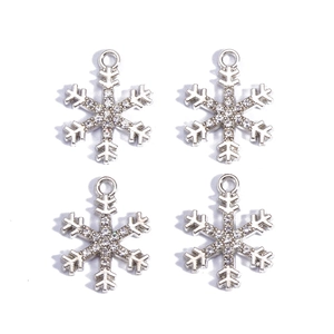 Macro detail of four silver snowflake charms with sparkling rhinestones for DIY jewelry