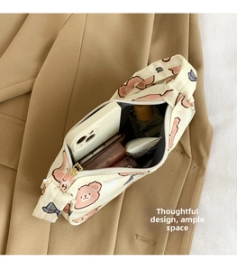 Detail view of a cute bear patterned shoulder bag showing interior storage for makeup