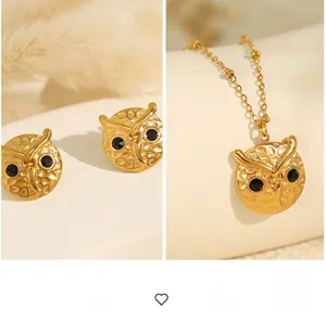 Detailed view of owl-shaped jewelry set with hammered gold texture and black stones