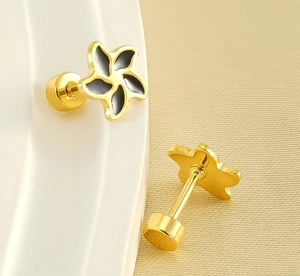 Detail view of gold-plated petal stud earrings with black enamel and screw back closure