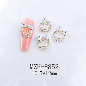 Détail macro de charmes d'ongles nœuds avec strass cœur Aurora et visages souriants