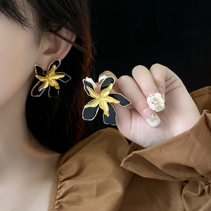 Close-up of model wearing black and gold floral earrings in vintage French style
