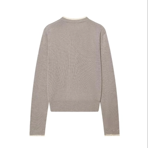 Detail view of the back of a taupe knit cardigan with white lace trim and fine texture