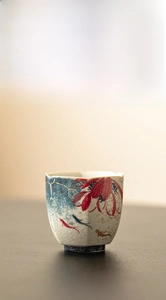 Detailed view of hand-painted koi and lotus on a ceramic hexagonal teacup with zen aesthetic