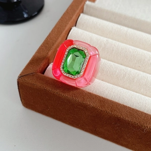Détail d'une bague vintage en résine avec pierre verte dans un écrin en velours