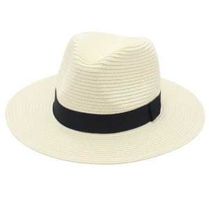 Detailed view of weave texture and black ribbon on a cream Panama straw hat