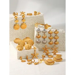 Marine theme jewelry set with 18K gold starfish earrings and shell rings on white stone