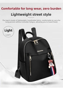 Detail of lightweight black oxford backpack featuring dual zippers and cute bear charm