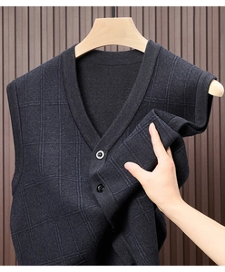 Detail shot of charcoal grey plaid knit vest showing fabric elasticity and V-neck button design