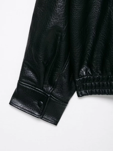 Detail view of black faux leather jacket cuffs and hem featuring premium lychee texture
