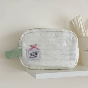 Detailed view of mint green polka dot elephant pouch with pink ribbon and quilted fabric